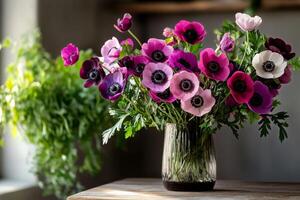 Colorful Bouquet of Anemone Flowers in a Glass Vase on a Wooden Table. photo