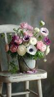 Beautiful Arrangement of Pastel Flowers in a Rustic Pot on a Vintage Chair. photo