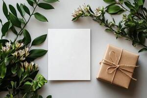 Hand Presenting Blank Card Among Wrapped Gifts and Tropical Leaves on Textured Surface. photo