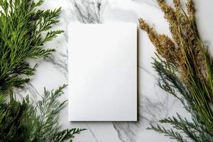 Fresh Greenery Placed in a Wooden Vase Beside a Blank Sheet of Paper on a Marble Surface. photo