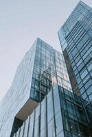 Skyscrapers Rising Towards a Cloudy Sky in an Urban Landscape With Glass Facades Reflecting Light. photo