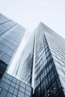 Skyscrapers Rising Towards a Cloudy Sky in an Urban Landscape With Glass Facades Reflecting Light photo