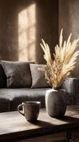 Modern Living Room With Cozy Couch and Decorative Vase of Dried Plants in Afternoon Light photo