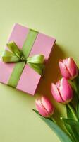 Pink Gift Box and Fresh Pink Tulips on a Green Background for Spring Celebrations and Special Occasions. photo