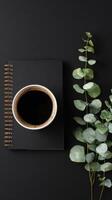Coffee Cup Placed on a Black Notebook Beside Fresh Greenery in Bright Daylight photo