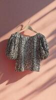 Elegant Sequin Top Displayed on Hanger Against Pastel Background in Indoor Setting. photo