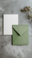Elegant Green Envelope and Blank Card With Leaves on Textured Surface. photo