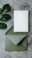 Elegant Green Envelope and Blank Card With Leaves on a Textured Surface photo