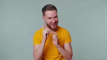 Sneaky cunning man with tricky face gesticulating and scheming evil plan, thinking over devious villain idea, cunning cheats, jokes and pranks. Young guy on gray studio wall background alone indoors video