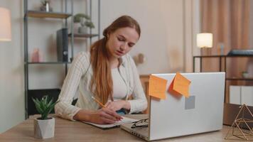 Exhausted woman freelancer using laptop computer with sticker notes on it having concentration problem, creative crisis. Nervous adult girl confused by big routine work loading indoors at home office video
