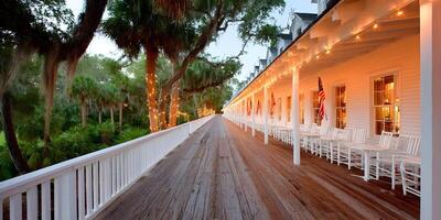 Long Wooden Porch with String Lights White Building and American Flags photo