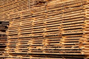 Stack of fresh pine boards in a sawmill warehouse photo