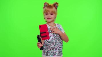 Happy funky young female blogger child kid girl, recording funny dancing on smartphone for social network or personal channel, having fun entertaining on weekend at home on chroma key background video