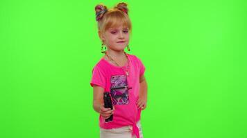 Happy funky young female blogger child kid girl, recording funny dancing on smartphone for social network or personal channel, having fun entertaining on weekend at home on chroma key background video