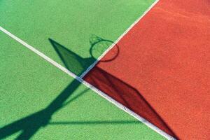 Colorful basketball outdoor court. Shadow of the rack with shield and basketball ring photo