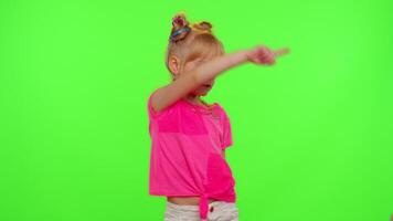 Cheerful funny little teen girl kid dancing at camera filming using phone at home on chroma key background. Schoolgirl child creating her trendy content on a mobile app to share on social media video
