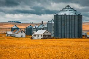 A farm with grain silos and a barn on a cloudy day photo