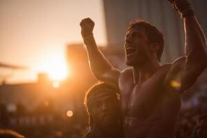A shirtless man is raising his arms in the air at sunset photo