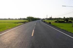 Winding road journey rural landscape photography green fields eye-level tranquil exploration photo