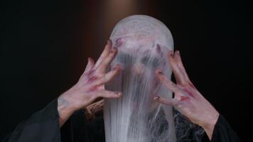 Sinister man with horrible scary Halloween zombie makeup in costume blows smoke from nose and mouth, screaming, shouting, trying to scare, breaks spider web. Dead guy with wounded bloody scars face video