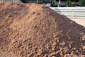 Excavation activity construction site soil pile urban environment ground level material handling photo
