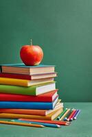 Colorful Stack of Books With Red Apple on Top Against Green Background in a Study Environment. photo