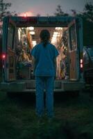 Medical Professional Stands Near Ambulance at Dusk in a Rural Area Preparing for Emergency Response photo