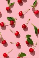 Bright Red Cherries Scattered on Pink Background for a Fresh Summer Feel photo