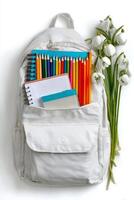 Colorful School Supplies and Flowers in a White Backpack on a Clean Background photo