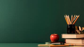 School Supplies Arranged on a Green Tabletop With an Apple and a Bag of Pencils. photo