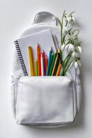 Colorful School Supplies and Flowers in a White Backpack on a Clean Background. photo