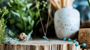 Delicate Fish Pendant Necklace Displayed on Rustic Wooden Table With Greenery in Background photo