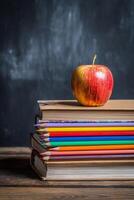 Colorful Pencils and Books With a Red Apple on Top for a School Setting photo