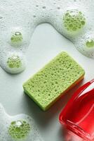 Cleaning Supplies Arranged With a Green Sponge and Soap Bubbles in a Bright Kitchen Setting photo