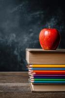 Colorful Pencils and Books With a Red Apple on Top for a School Setting. photo