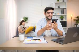Portrait of a young freelancer smiling while working online via laptop at home with his girlfriend,203 photo