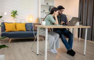 Portrait of a young freelancer smiling while working online via laptop at home with his boyfriendYoung couple are smiling while relax and working online via laptop in living room at home,140 photo