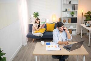 Portrait of a young freelancer smiling while working online via laptop at home with his girlfriendYoung couple are smiling while relax and working online via laptop in living room at home,139 photo