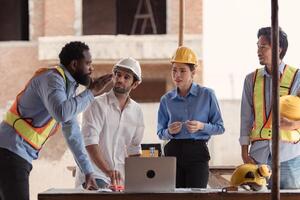 Group of architects and engineers work together to assess the residential home construction site's progress,214 photo