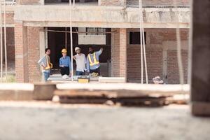 Group of architects and engineers work together to assess the residential home construction site's progress,211 photo