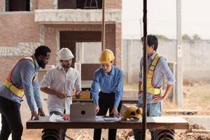 Group of architects and engineers work together to assess the residential home construction site's progress,208 photo