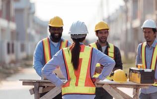 Group of architects and engineers work together to assess the residential home construction site's progress,206 photo