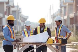 Group of architects and engineers work together to assess the residential home construction site's progress,180 photo
