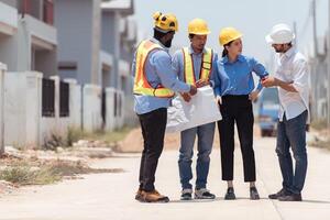 Group of architects and engineers work together to assess the residential home construction site's progress,177 photo