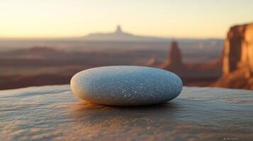 Smooth gray stone atop a rock formation, sunrise backdrop photo