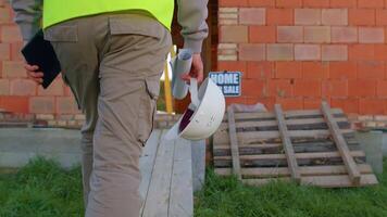 Real estate foreman designer building project architect. Professional civil engineer developer builder with helmet in hand walking to construction site. Constructor foreman. Start of working day video
