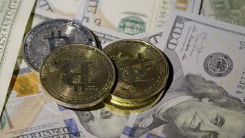 Bitcoin BTC coin and Ethereum ETH coins are rotating on bills cash of 100 dollars. Mining virtual money. Digital coin cyberspace and cryptocurrency. Stock exchange market trading, online payment video