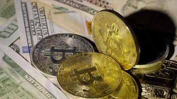 Bitcoin BTC coin and Ethereum ETH coins are rotating on bills cash of 100 dollars. Mining virtual money. Digital coin cyberspace and cryptocurrency. Stock exchange market trading, online payment video