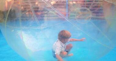Child Playing Inside Inflatable Water Ball on Pool Surface video
