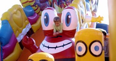 Child Enjoying Colorful Inflatable Slide at Amusement Park video